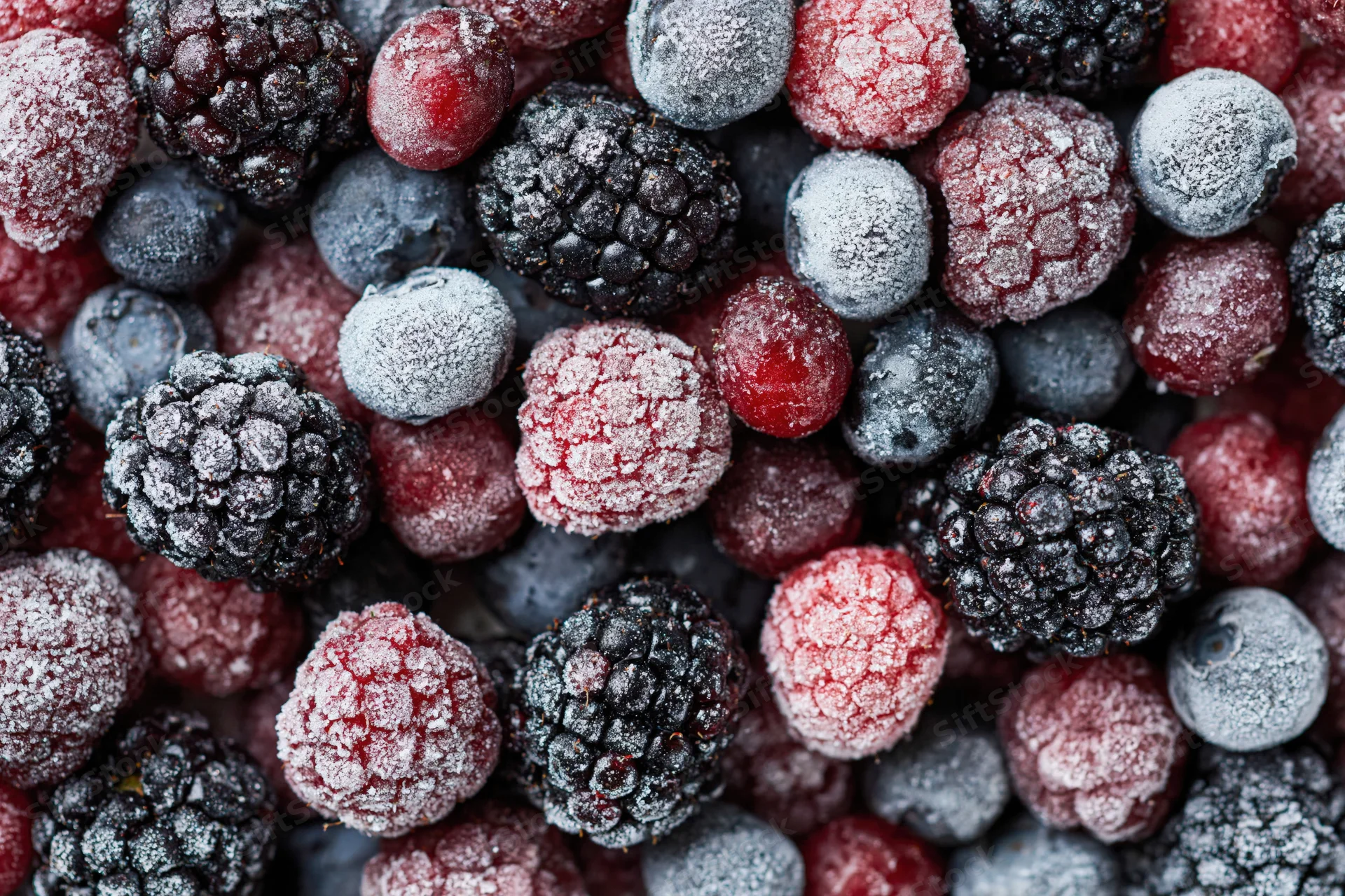 Frozen mixed berries covered in frost filling the frame