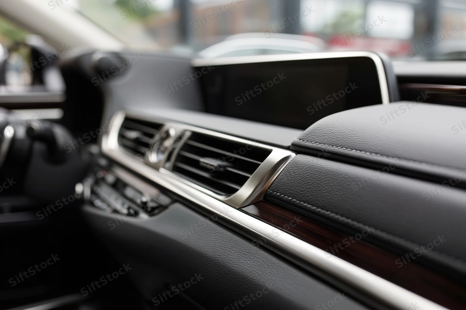Luxury sedan dashboard and center console interior with leather, wood trim and chrome accents