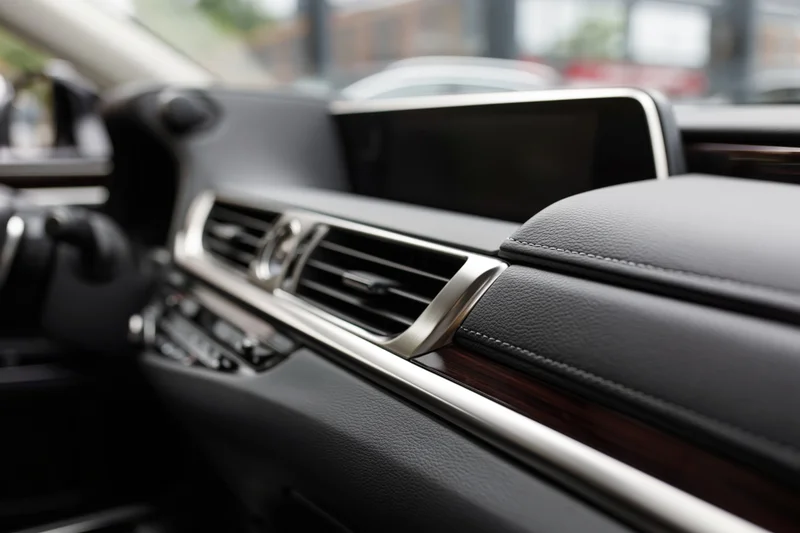Luxury sedan dashboard and center console interior with leather, wood trim and chrome accents