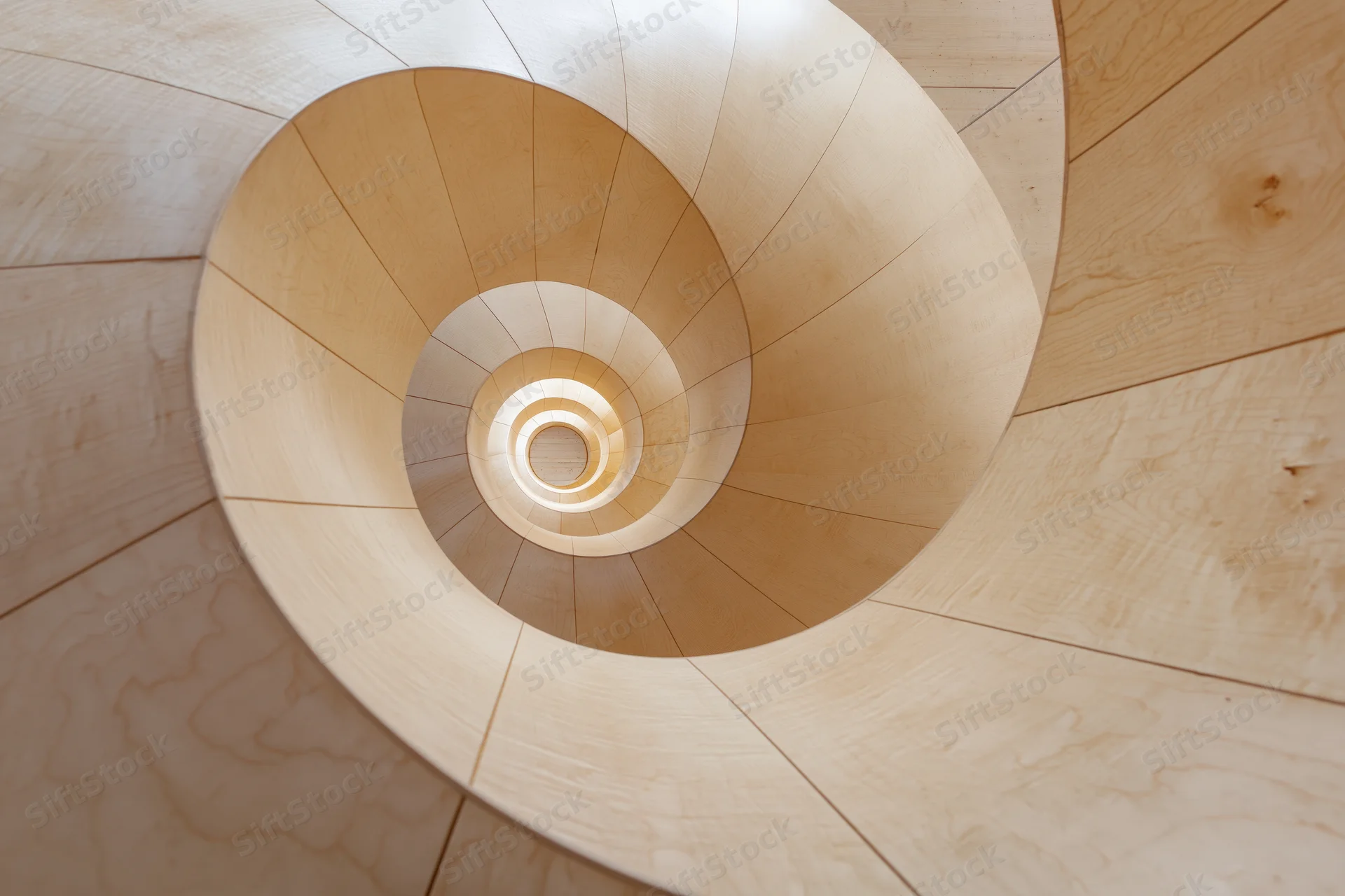 Looking up through a spiral wooden staircase interior