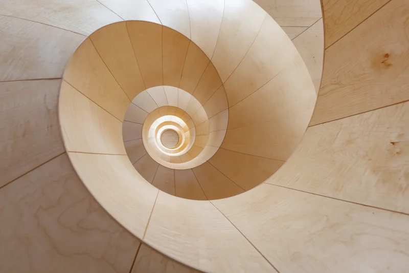 Looking up through a spiral wooden staircase interior