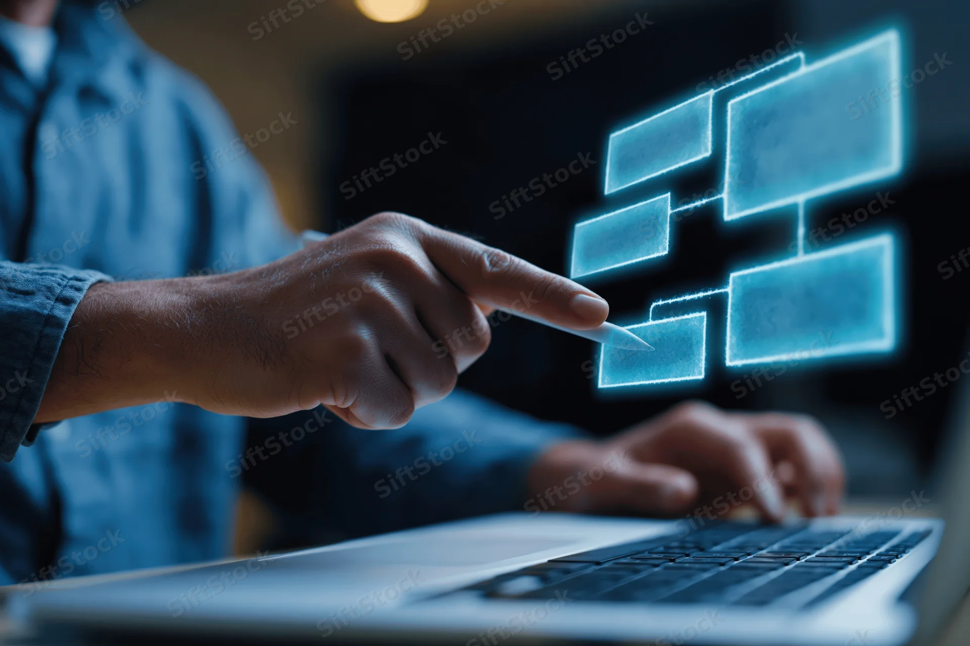 Man pointing stylus at glowing holographic flowchart above laptop keyboard