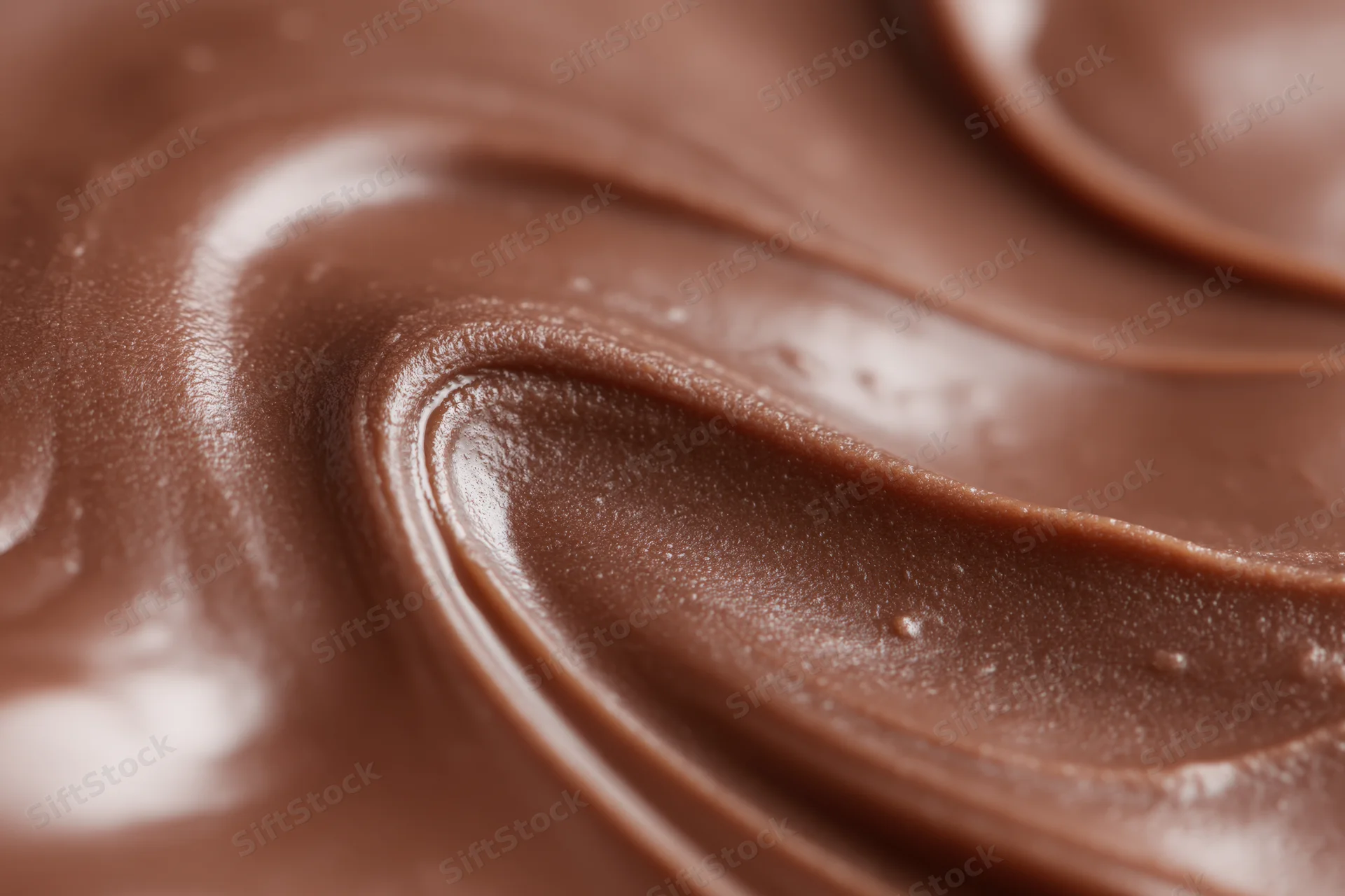 Closeup of melted milk chocolate with smooth swirling texture