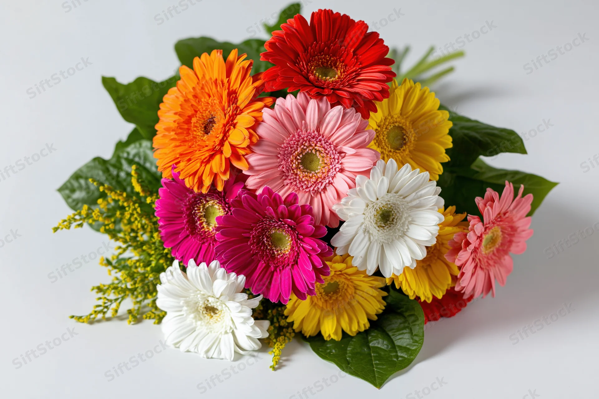 Mixed gerbera daisy bouquet arranged loosely on white surface