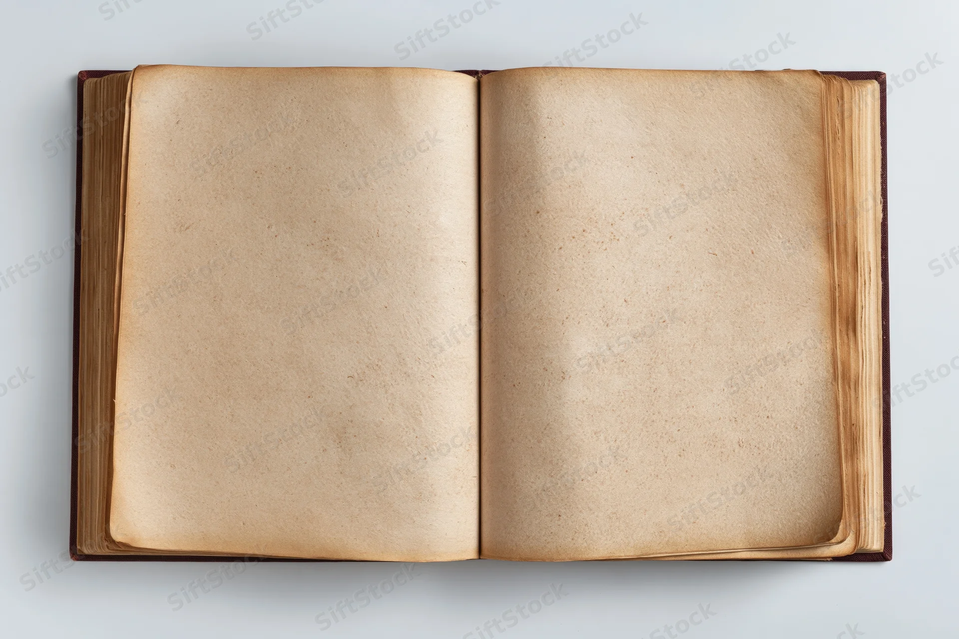 Open hardcover book with blank aged pages lying flat on white surface