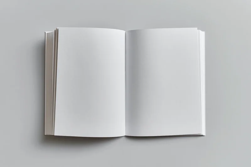 Open blank white paperback book lying flat on gray surface
