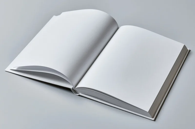 Open hardcover book with blank white pages lying flat on a gray surface