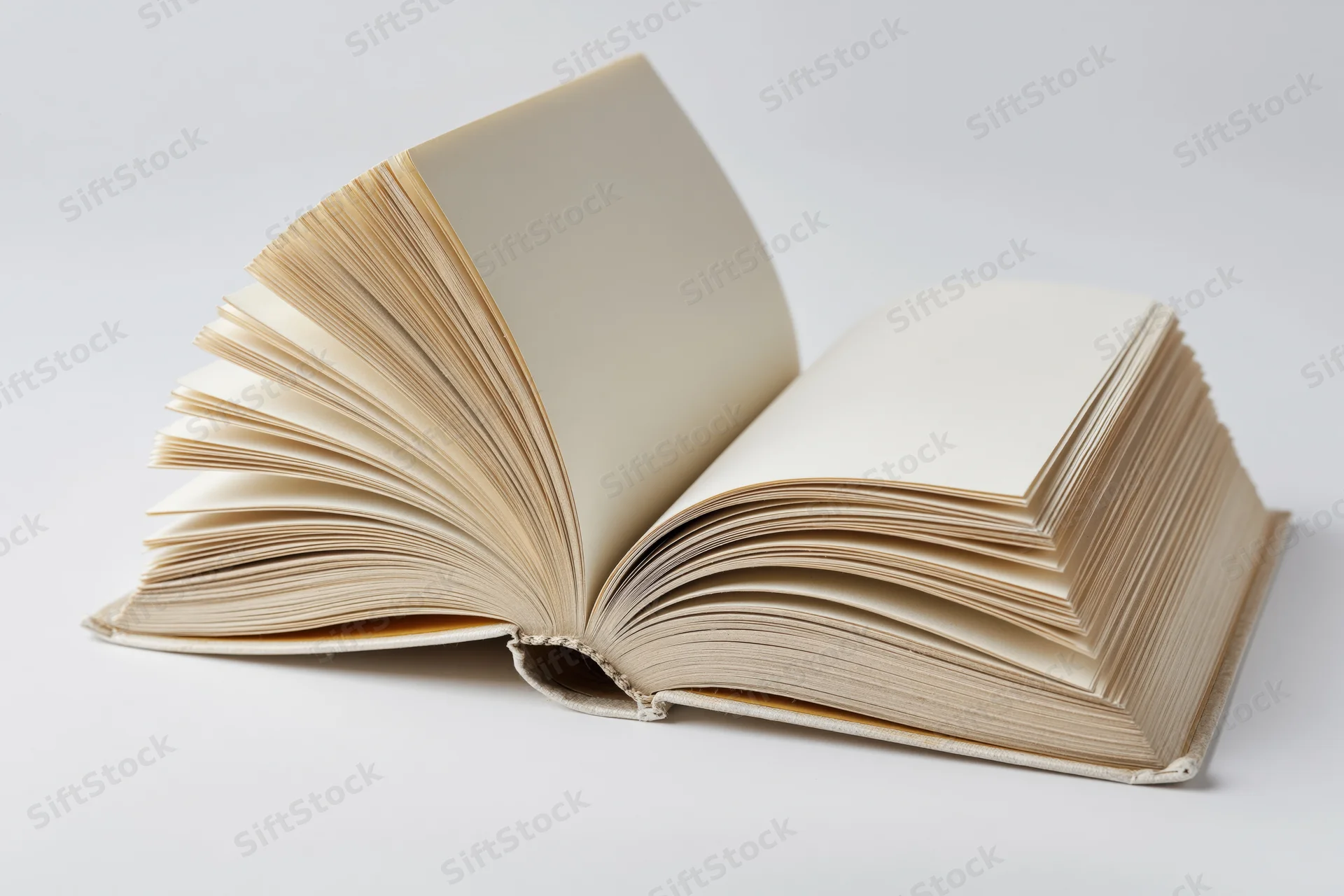 Open hardcover book with pages fanned out on white background