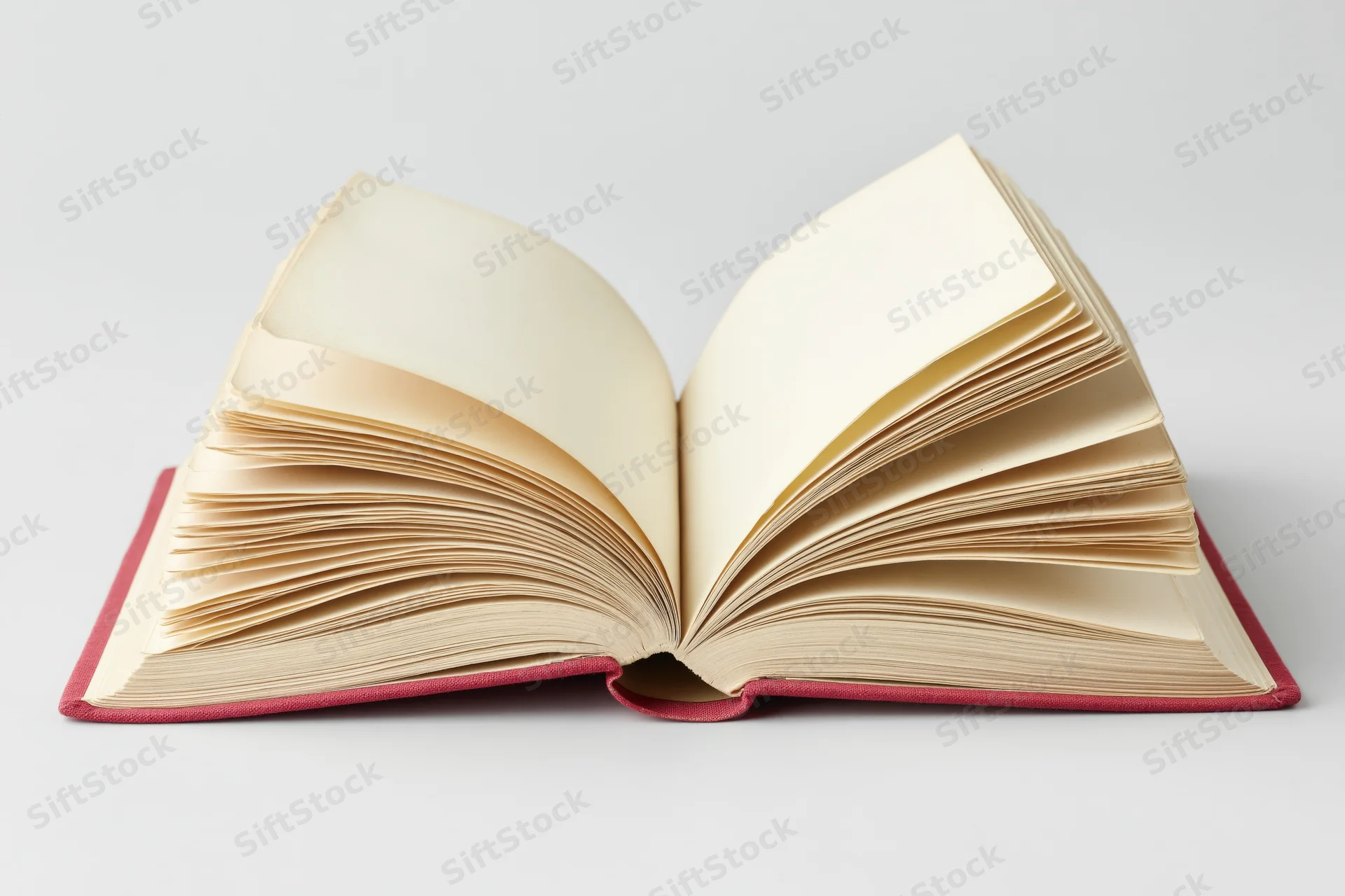 Open hardcover book with pages fanned wide and spine resting flat on white surface