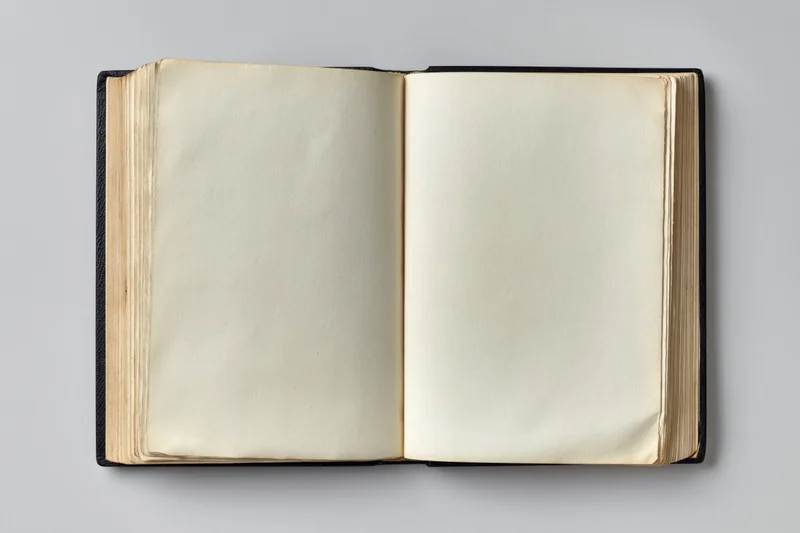 Open vintage hardcover book with blank cream pages on gray background