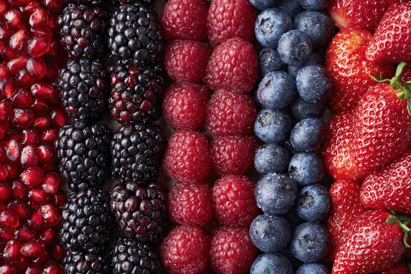 Overhead flat-lay of mixed fresh berries arranged in vertical rows