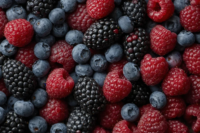 Overhead flat lay of mixed fresh berries covering the entire frame