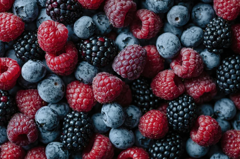 Overhead closeup of mixed fresh berries covering the entire frame