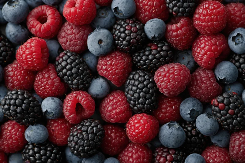 Overhead flat lay of mixed fresh berries covering the entire frame