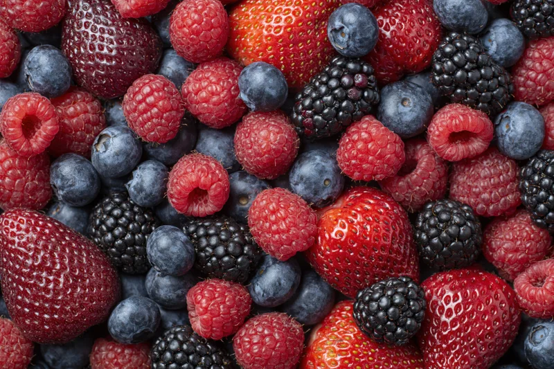 Overhead flat lay of mixed fresh berries filling the frame