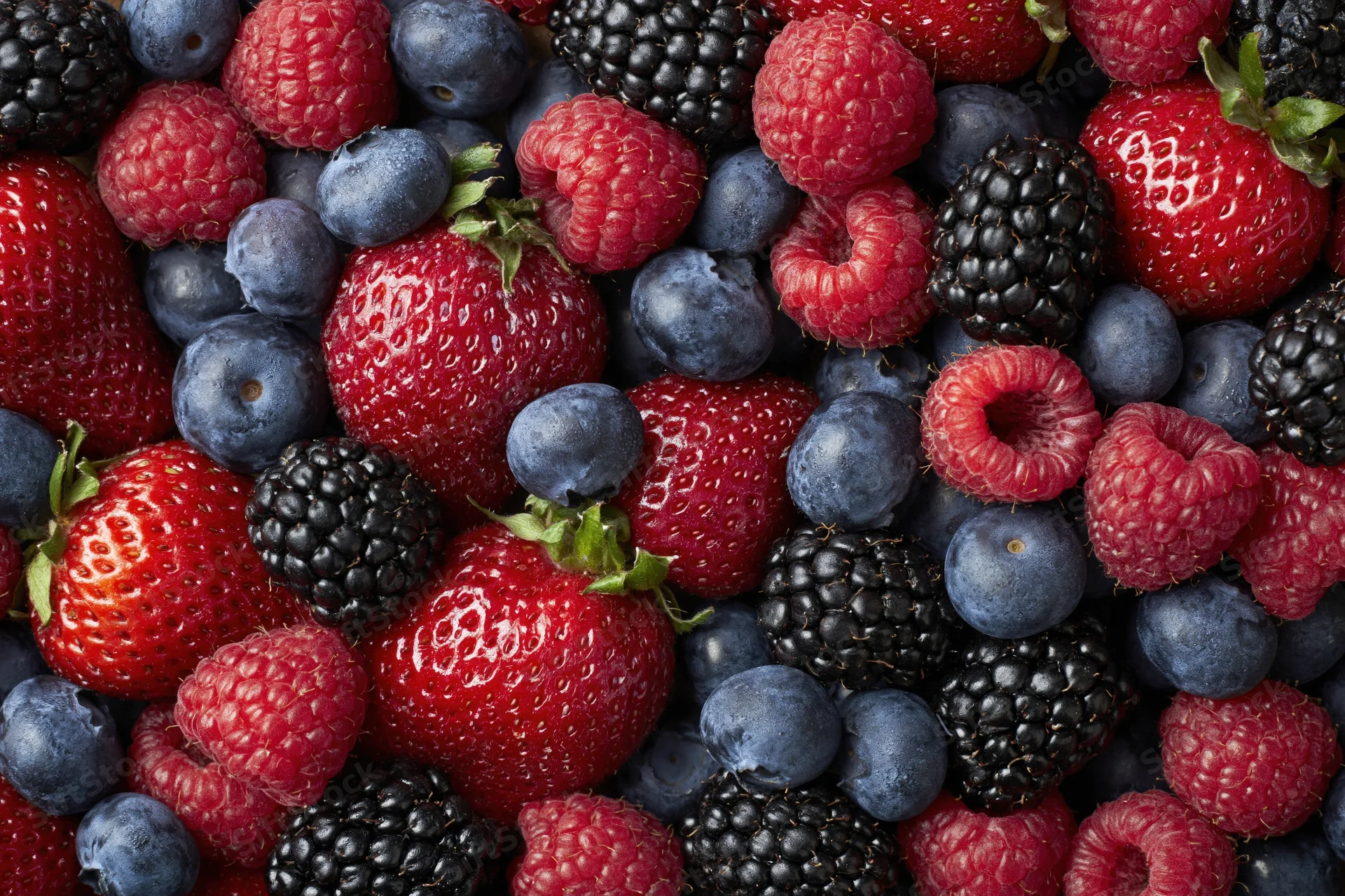Overhead flat lay of mixed fresh berries filling the frame