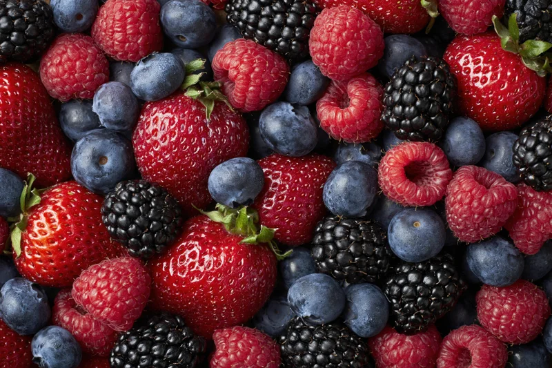 Overhead flat lay of mixed fresh berries filling the frame