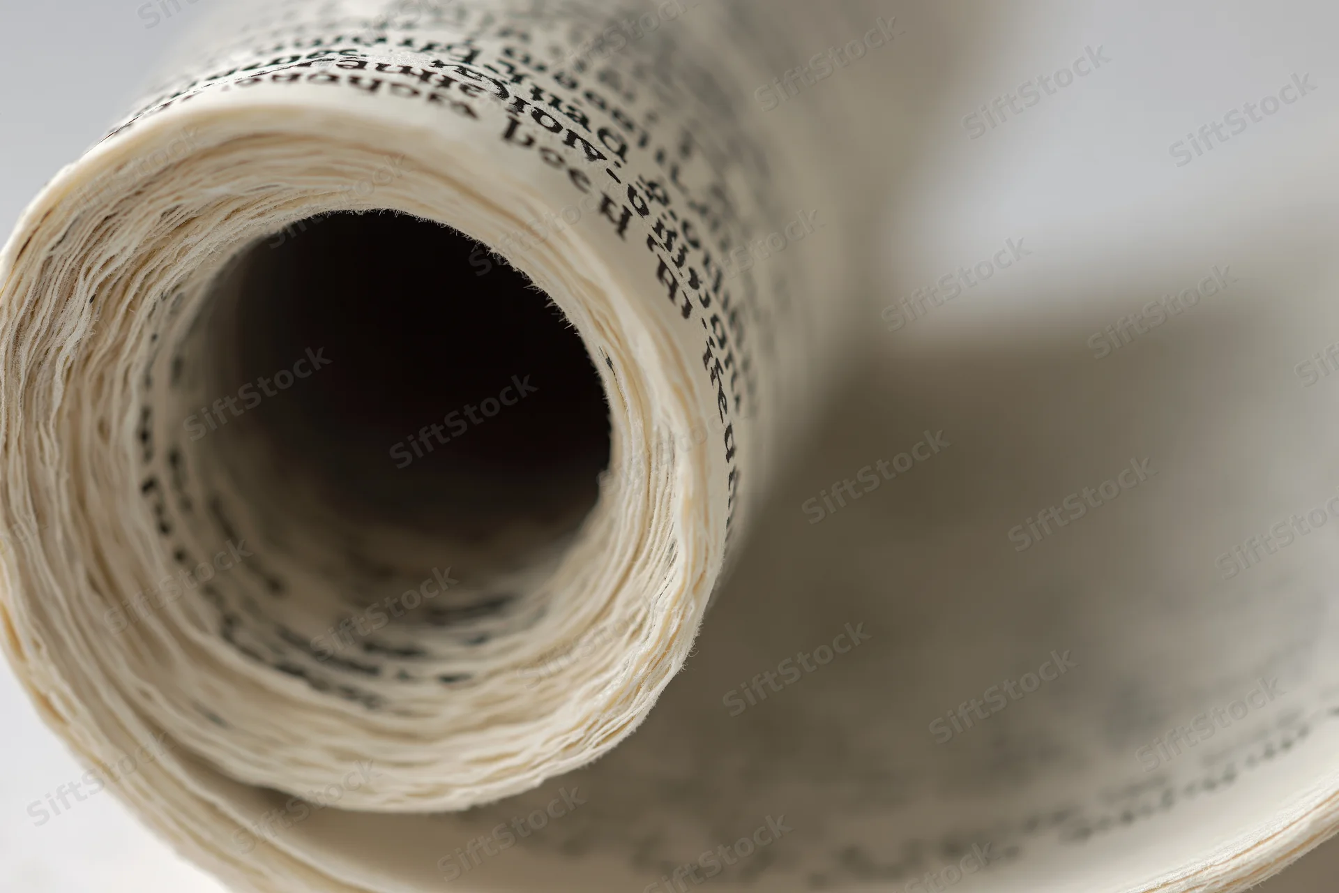 Rolled book pages forming a spiral tunnel with visible text and paper texture