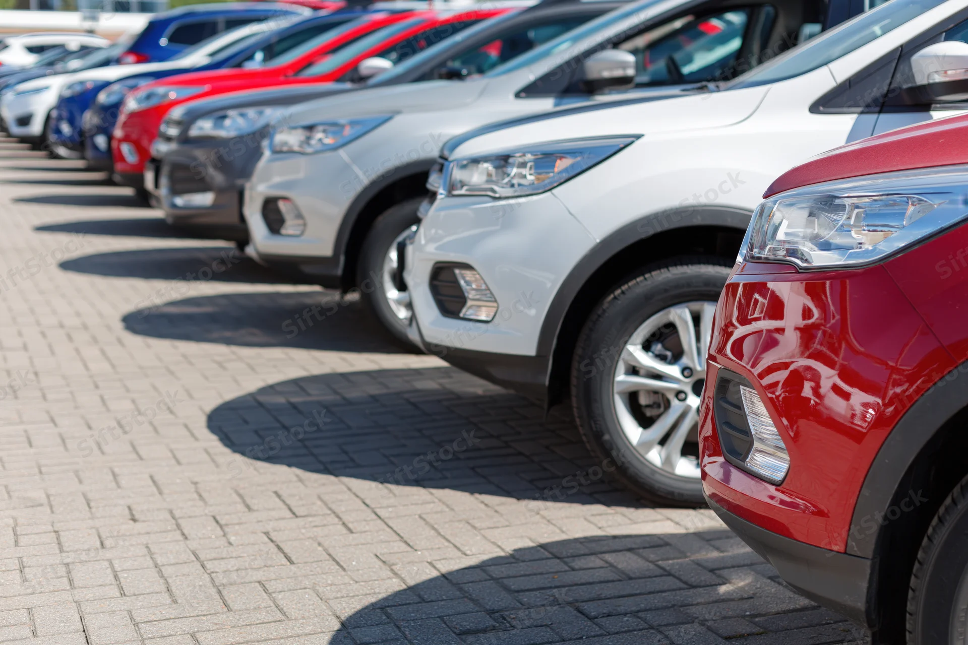 Row of suvs and crossovers parked diagonally in a dealership lot