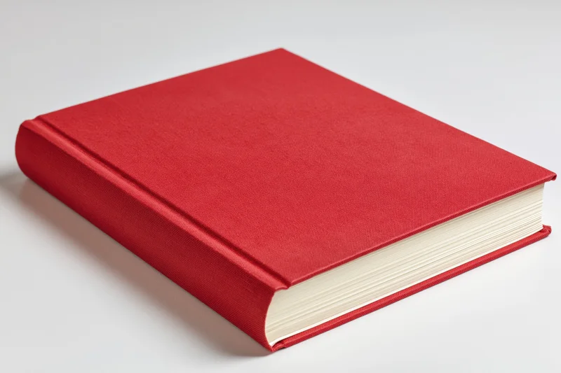 Red hardcover book closed on white surface