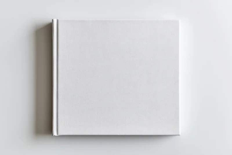 Square hardcover book with blank white cover lying flat on white surface