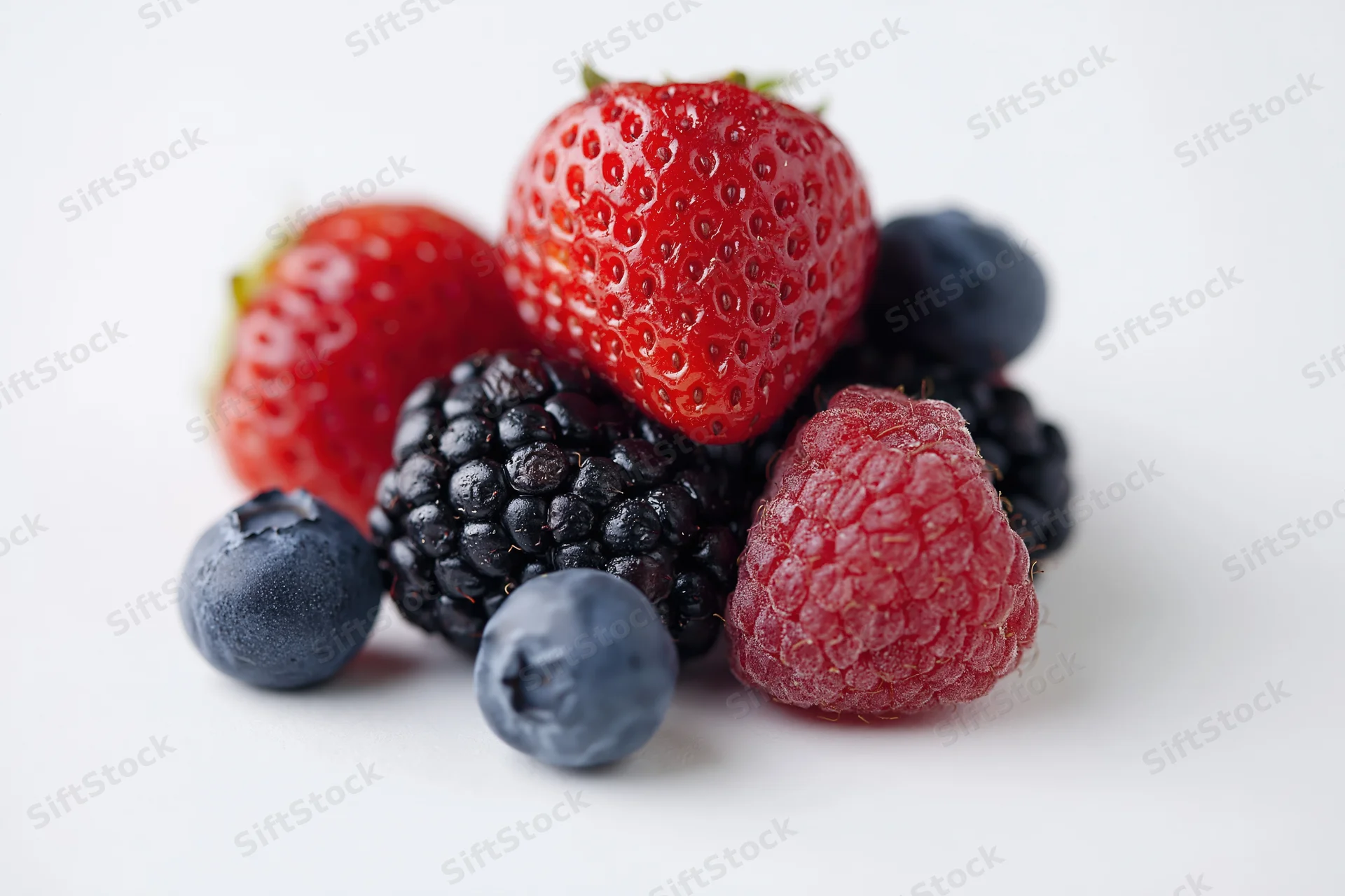 Mixed fresh berries arranged on a white background