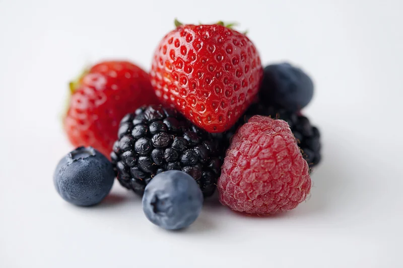 Mixed fresh berries arranged on a white background