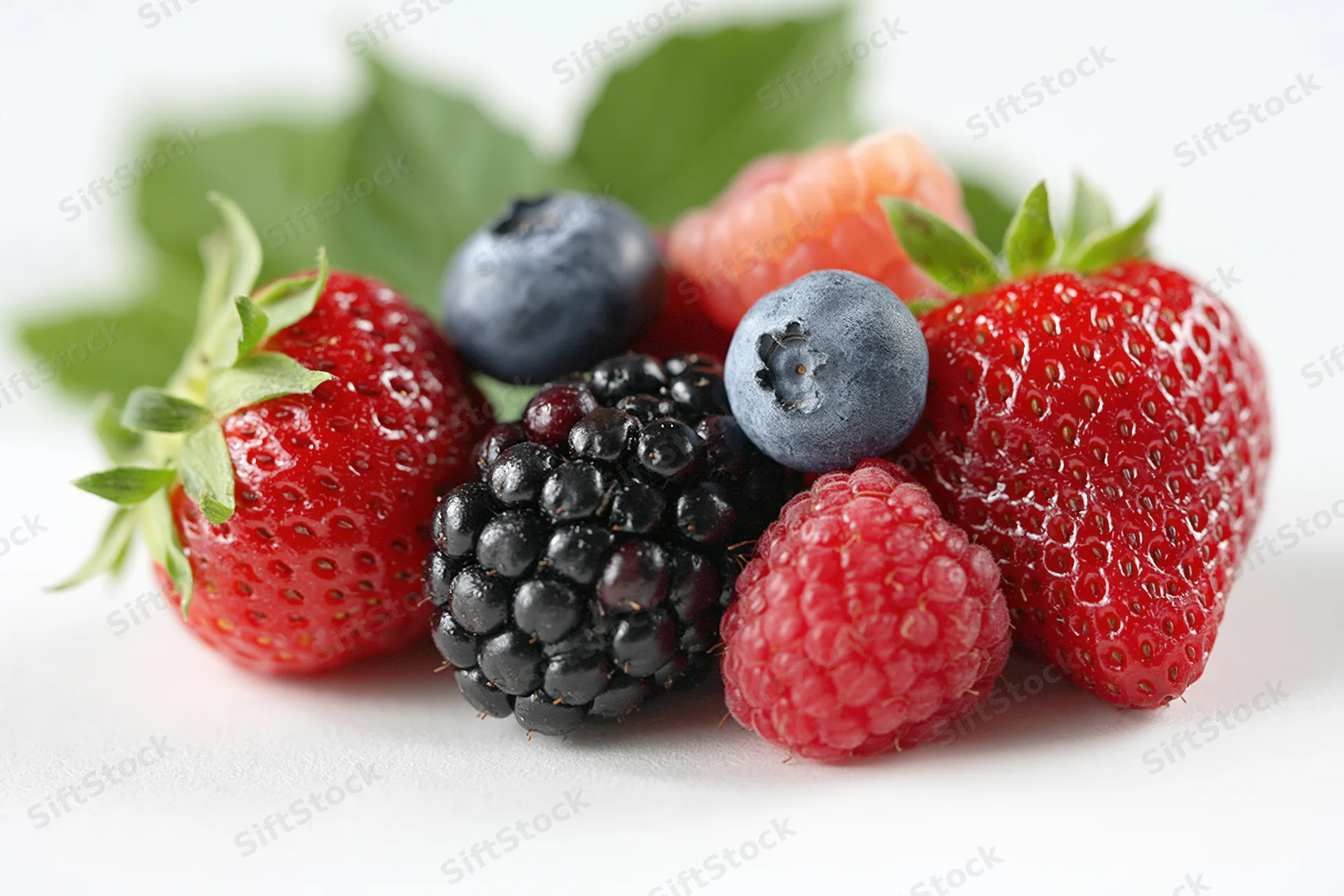 Mixed fresh berries arranged on a white surface