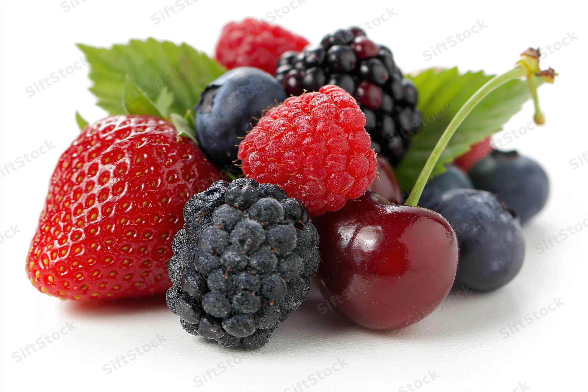 Mixed fresh berries arranged together on white background