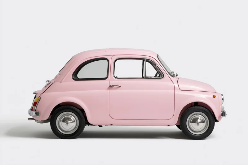 Vintage pink italian compact car in side profile against white background