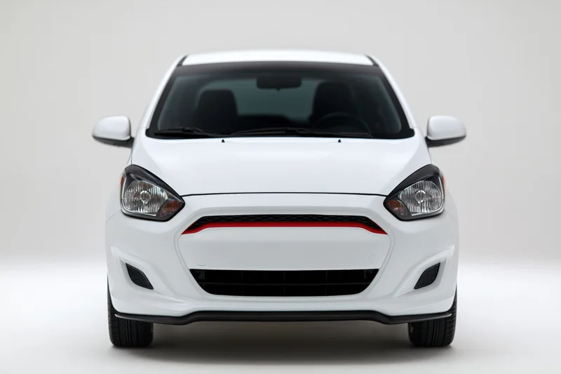 White compact hatchback viewed straight-on in studio setting