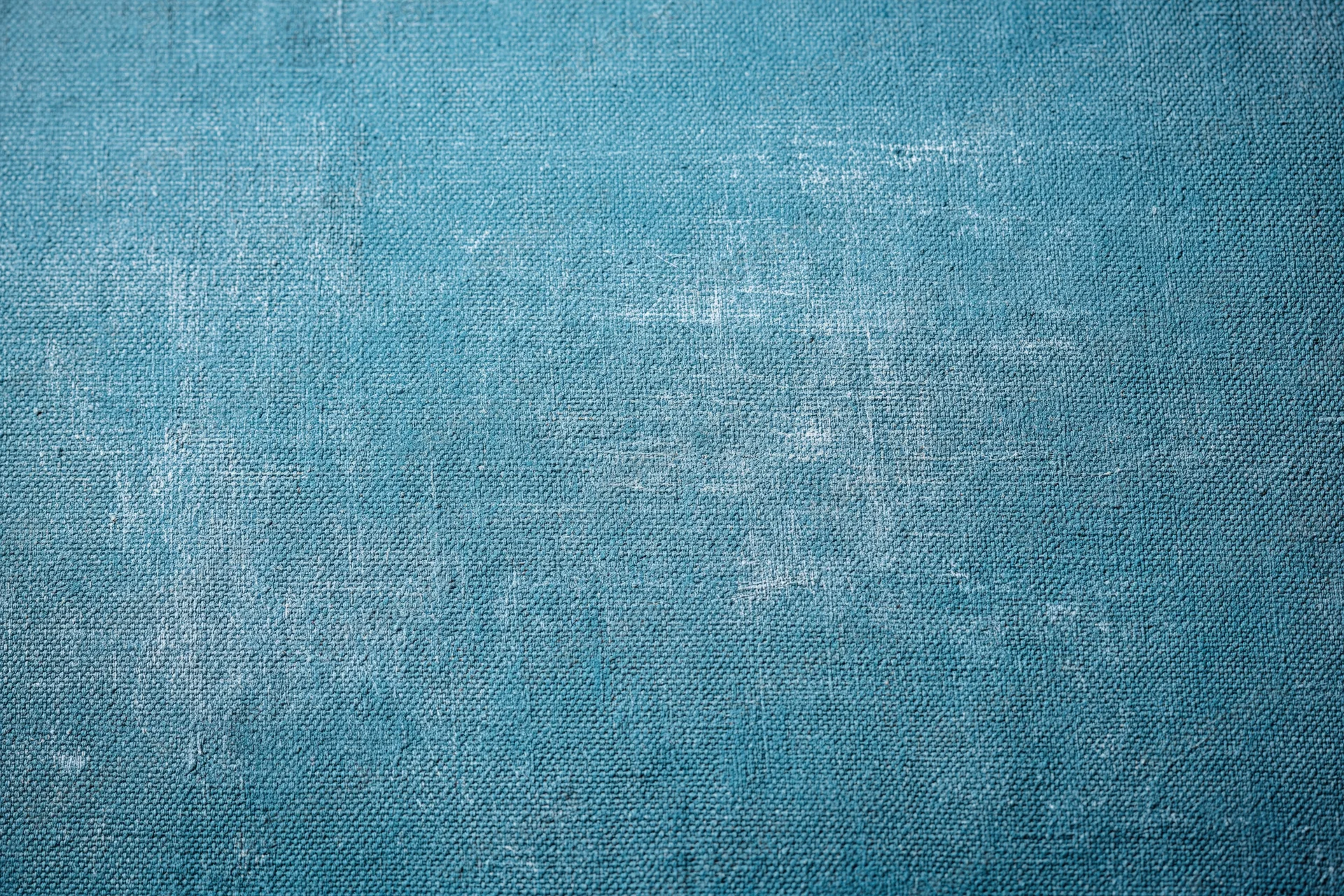 Worn teal-painted canvas texture filling the frame