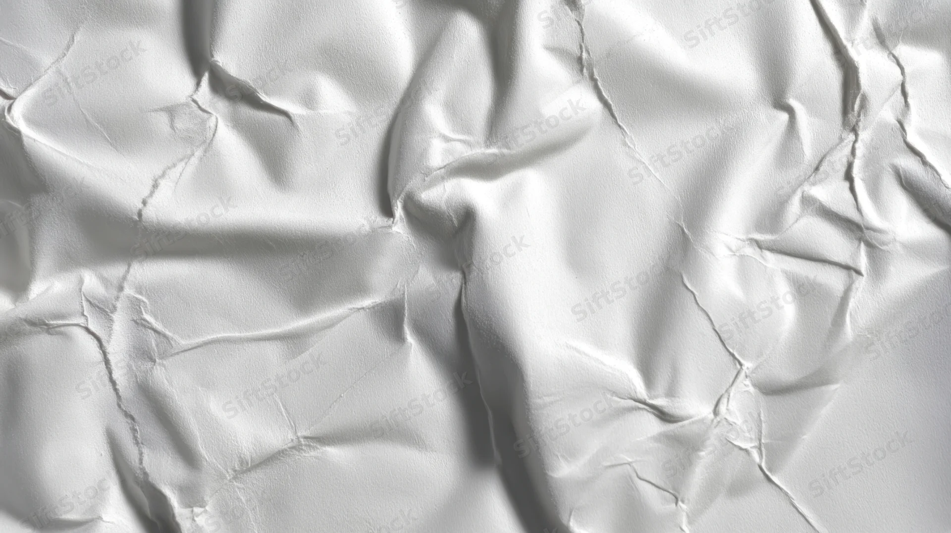 Close-up of crumpled white paper with creases and folds forming a textured surface