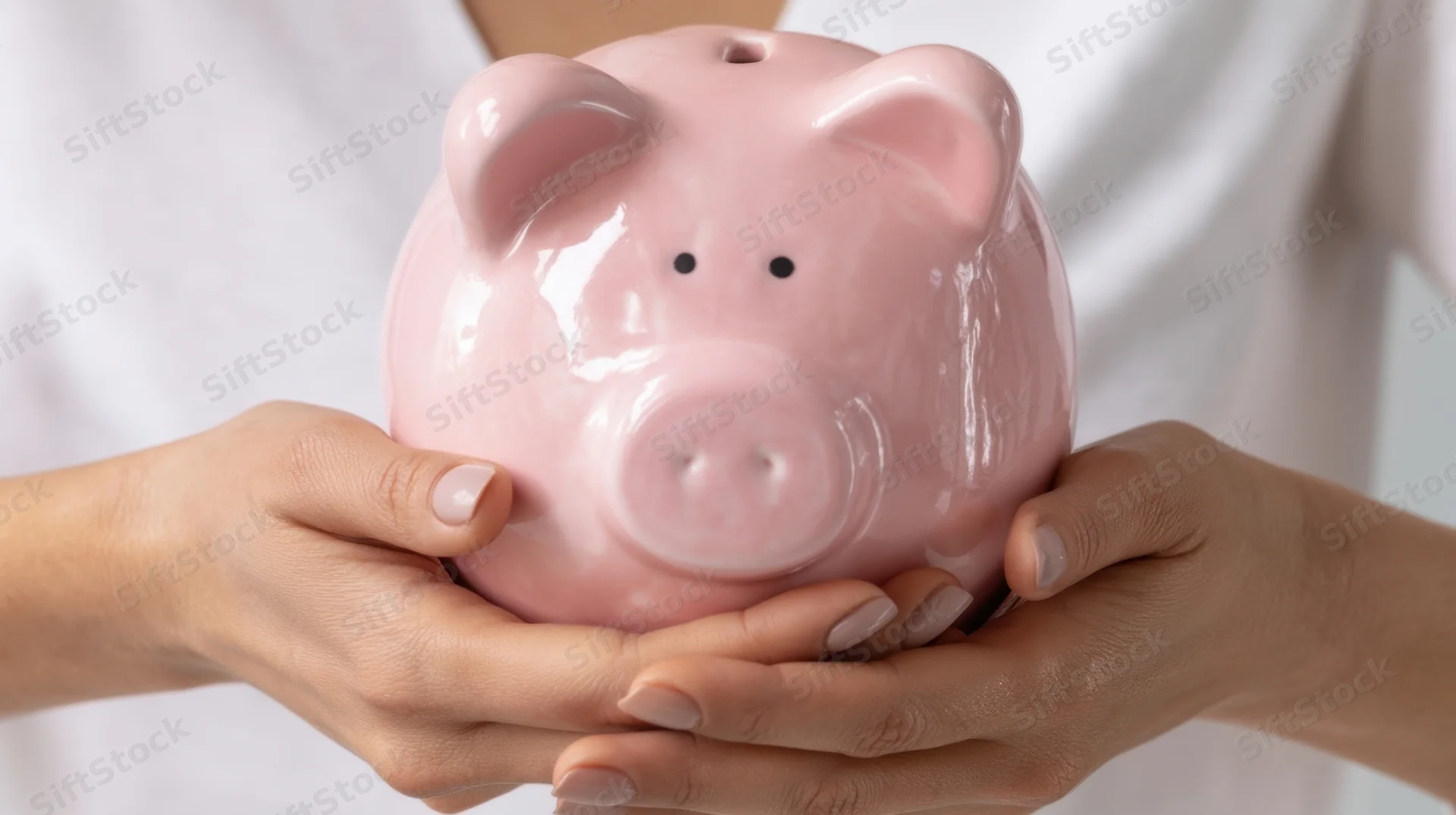 Woman holding a pink ceramic piggybank with both hands