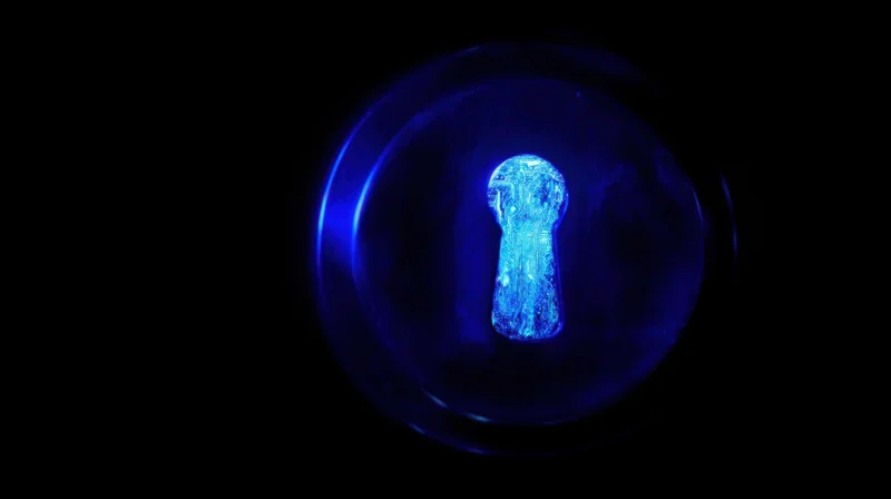 Glowing blue digital keyhole in dark background