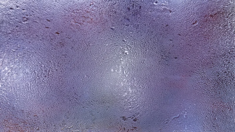 Closeup of water droplets on a foggy glass surface