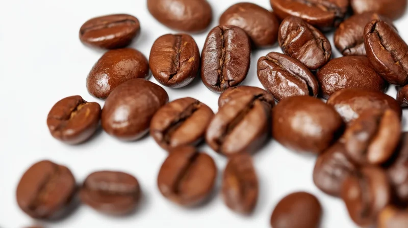 Scattered roasted coffee beans on white background