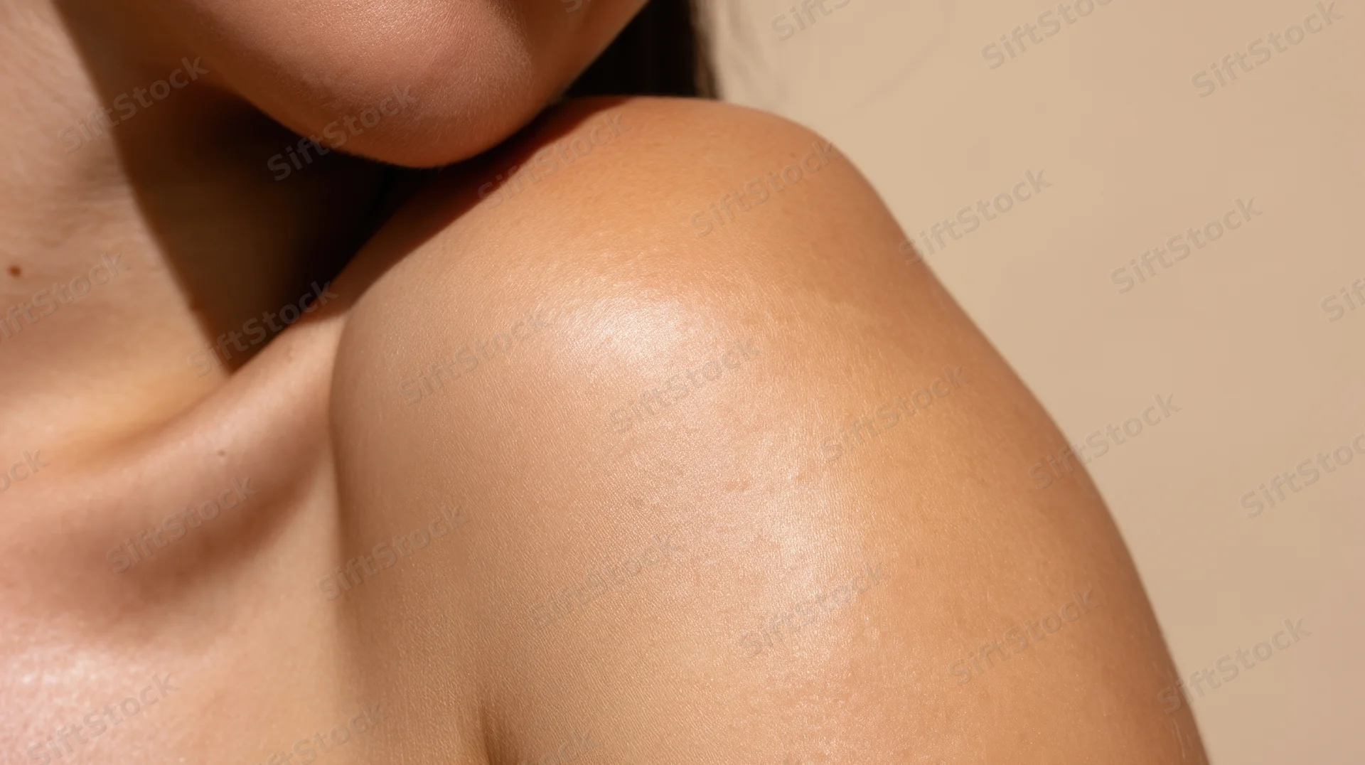 Closeup of a woman's smooth shoulder and neck skin showing natural glow and texture