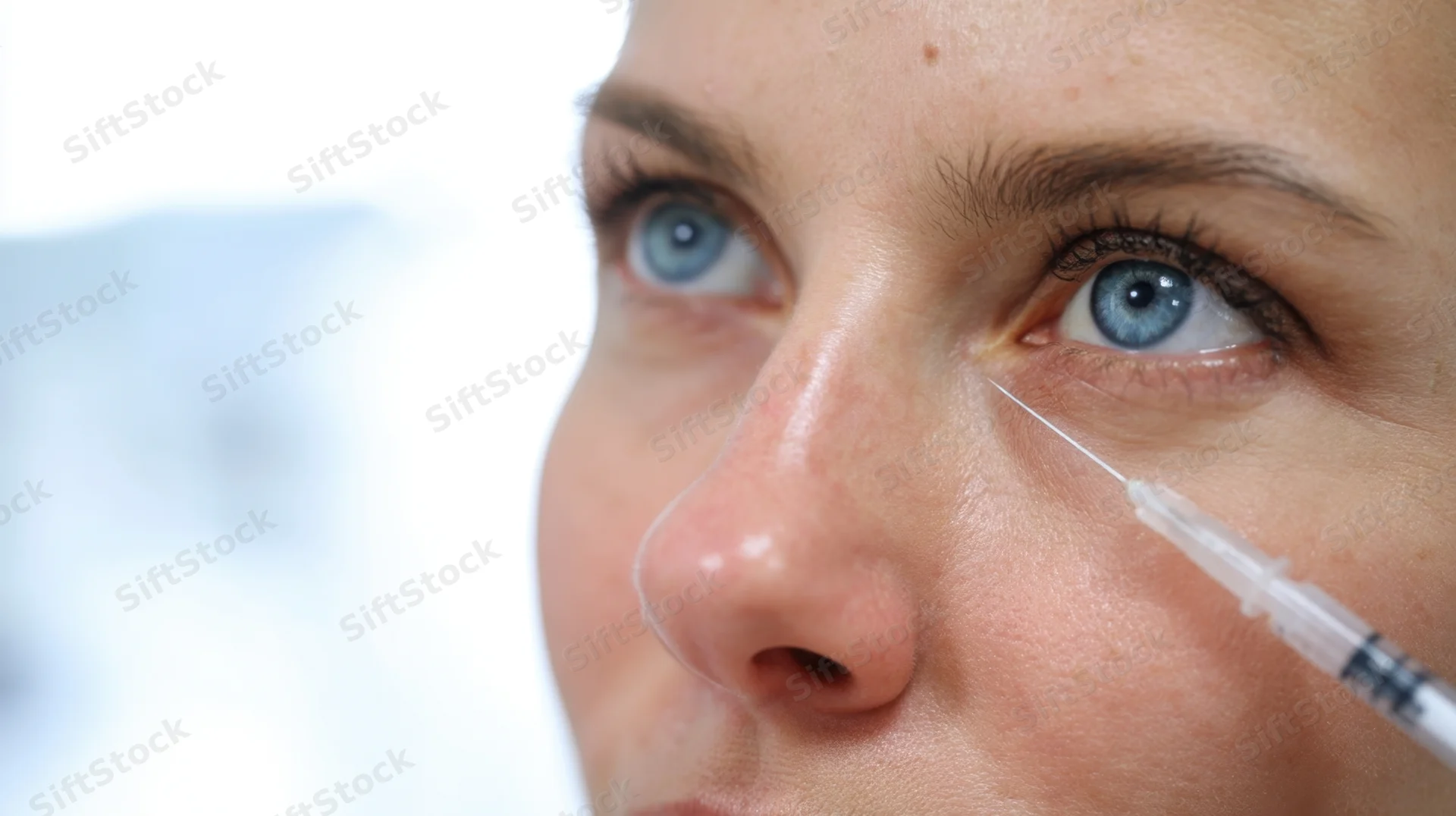 Close-up of a woman receiving a facial injection near her eye in a medical setting