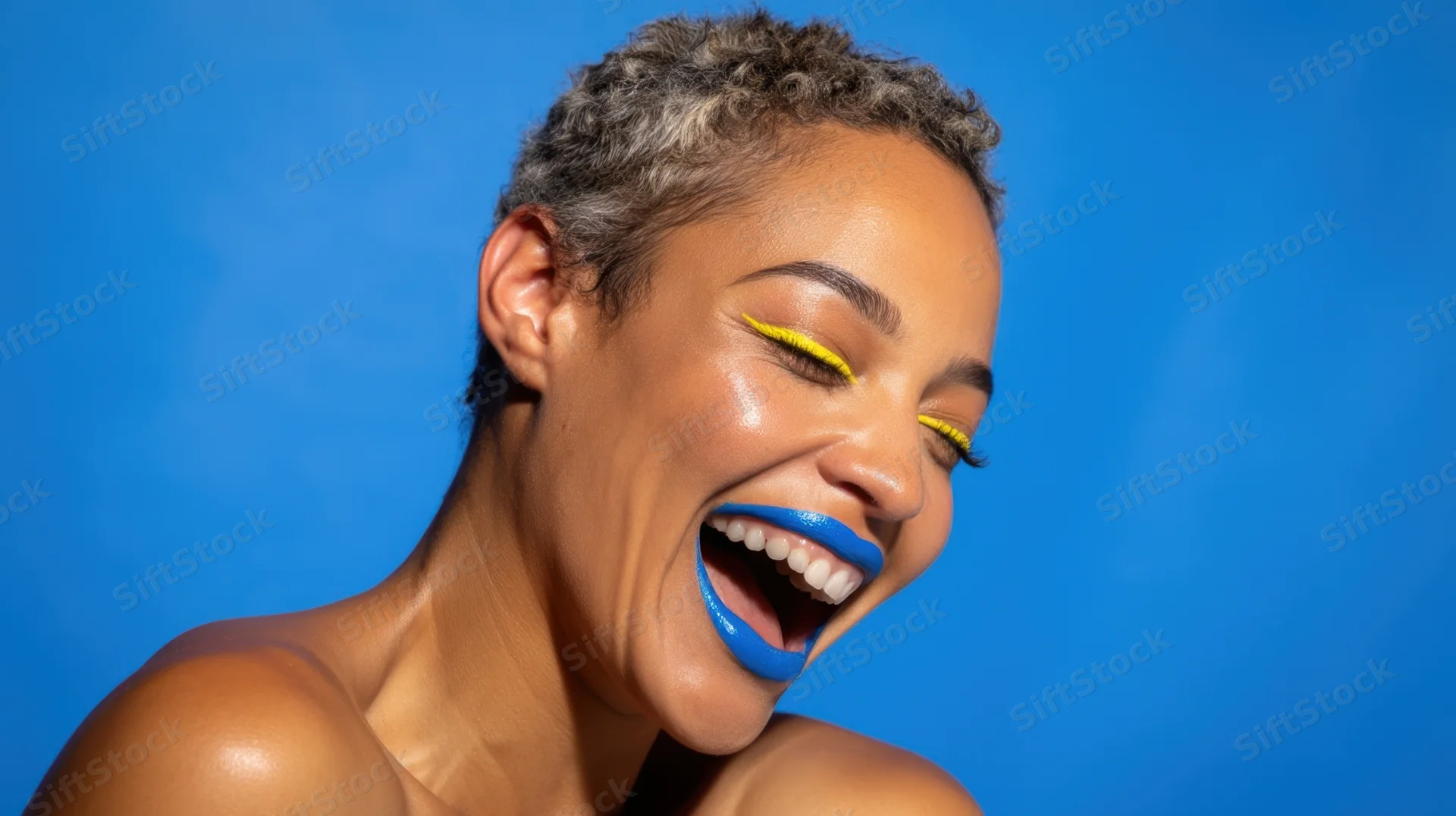 Woman laughing with blue lips and yellow eyeliner against blue background