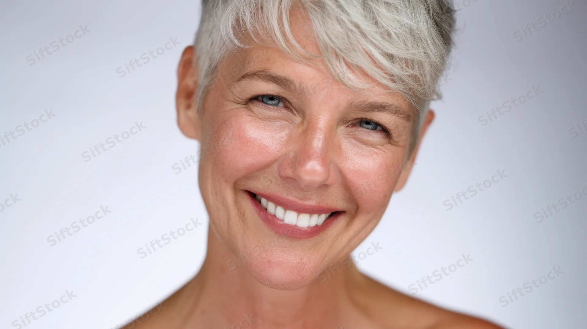 Smiling mature woman with short gray hair in studio portrait