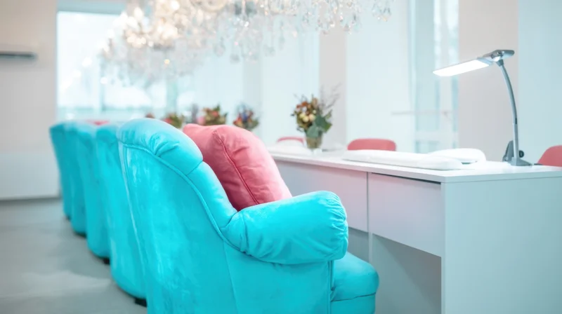 Turquoise chairs lined along a white reception desk in a modern salon interior