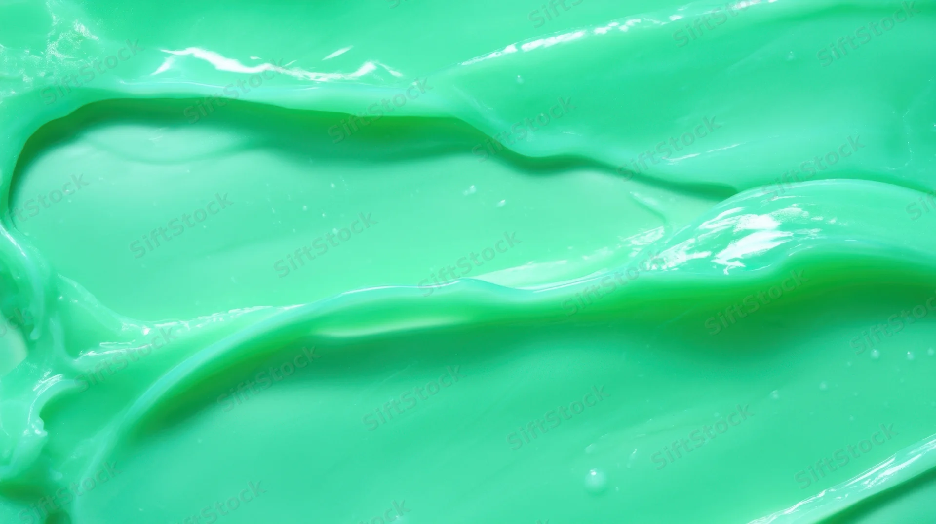 Close-up of smooth green cream with glossy swirled texture