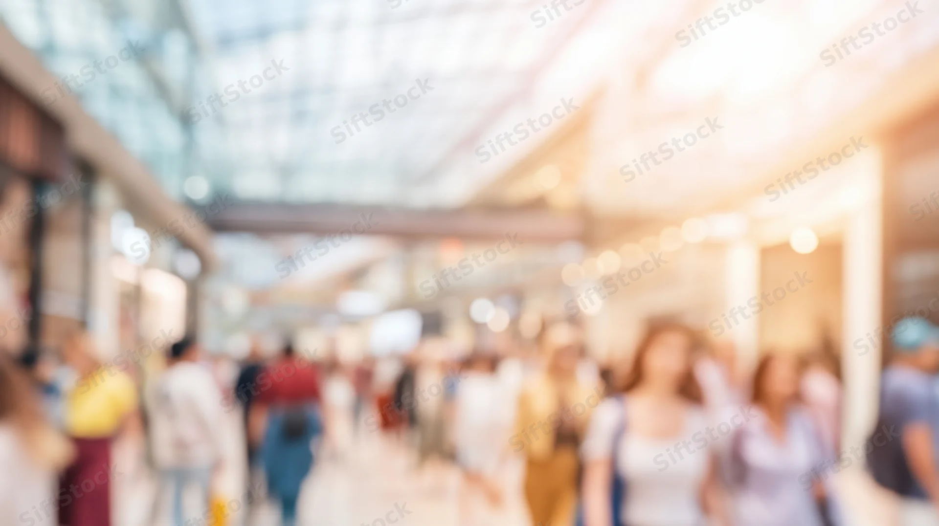 Blurred view of people walking through a shopping mall interior