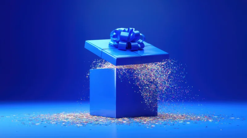 Blue gift box with ribbon opening to release confetti against a blue background