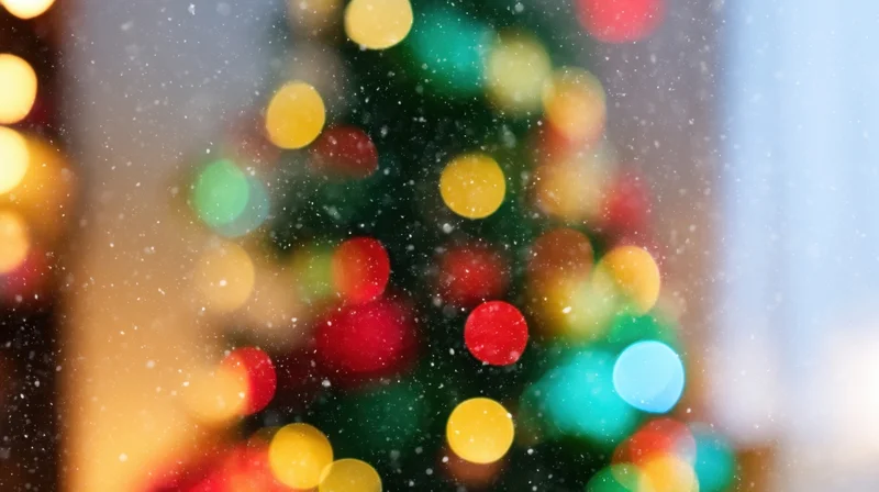 Blurred christmas tree lights with snow falling in the foreground