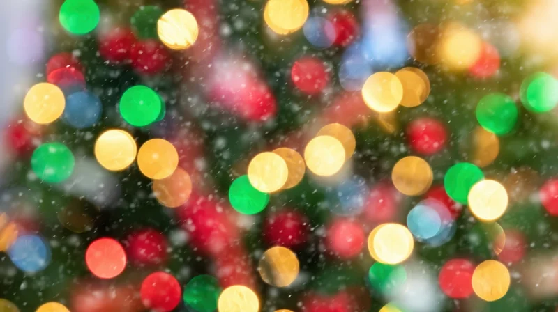 Blurred colorful lights on a christmas tree with falling snow