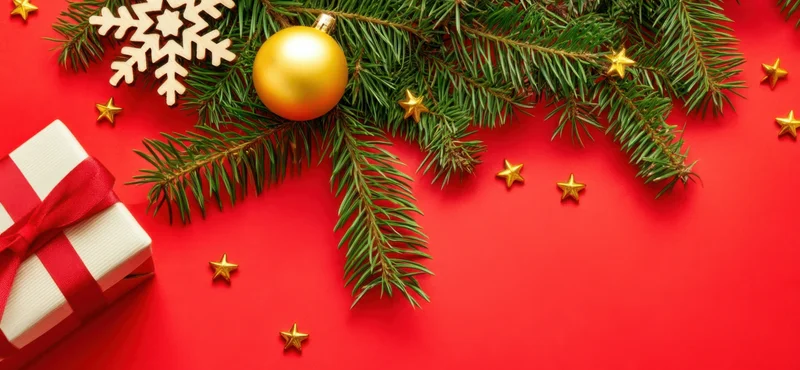 Christmas decorations and gift on red background with copyspace