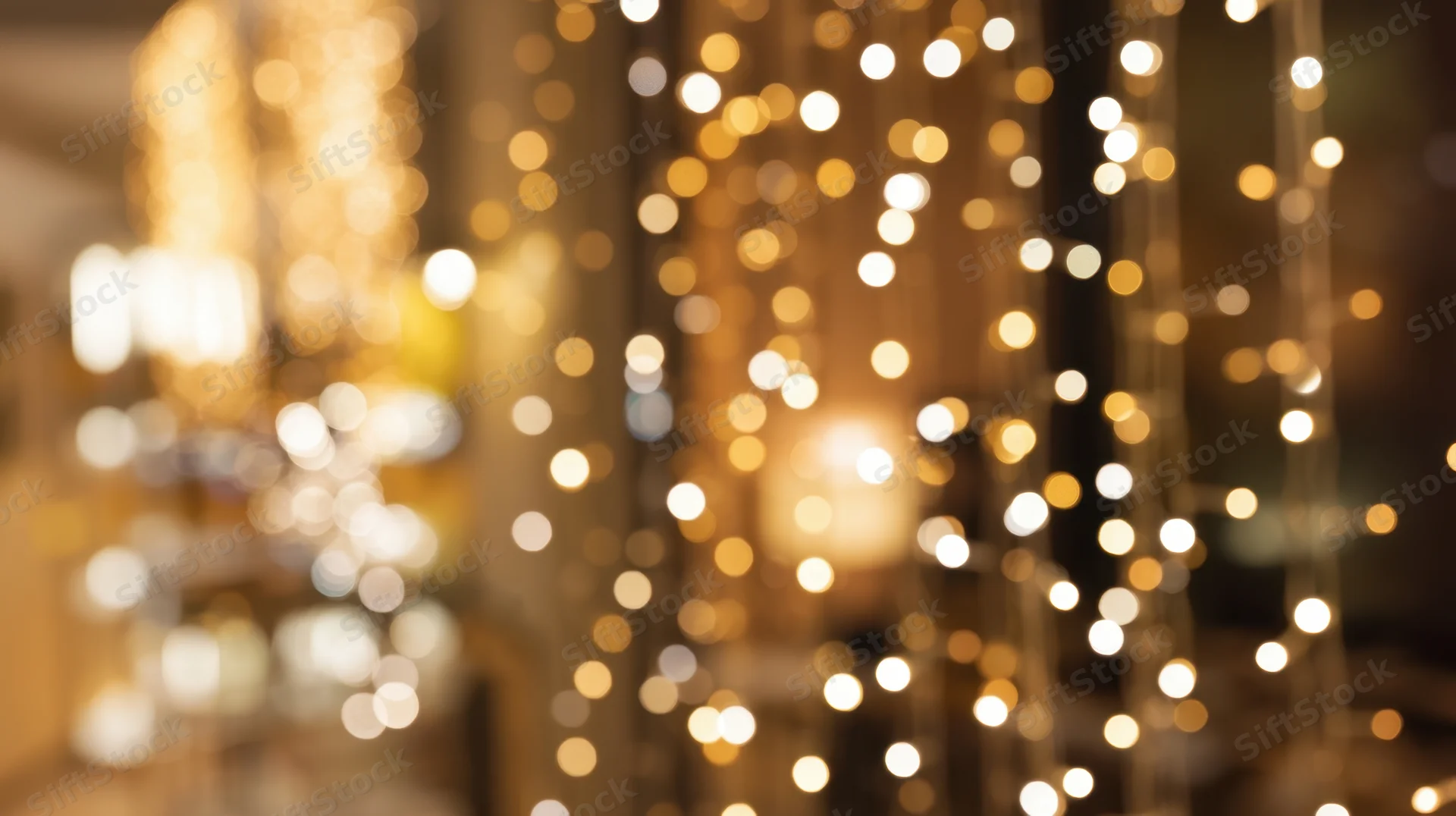 Blurred golden bokeh lights creating warm festive ambiance in interior space