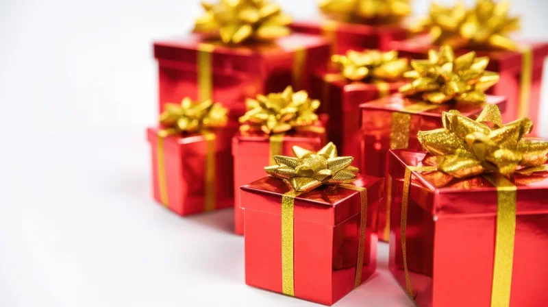 Red gift boxes with gold ribbons and bows arranged in varying sizes on white background